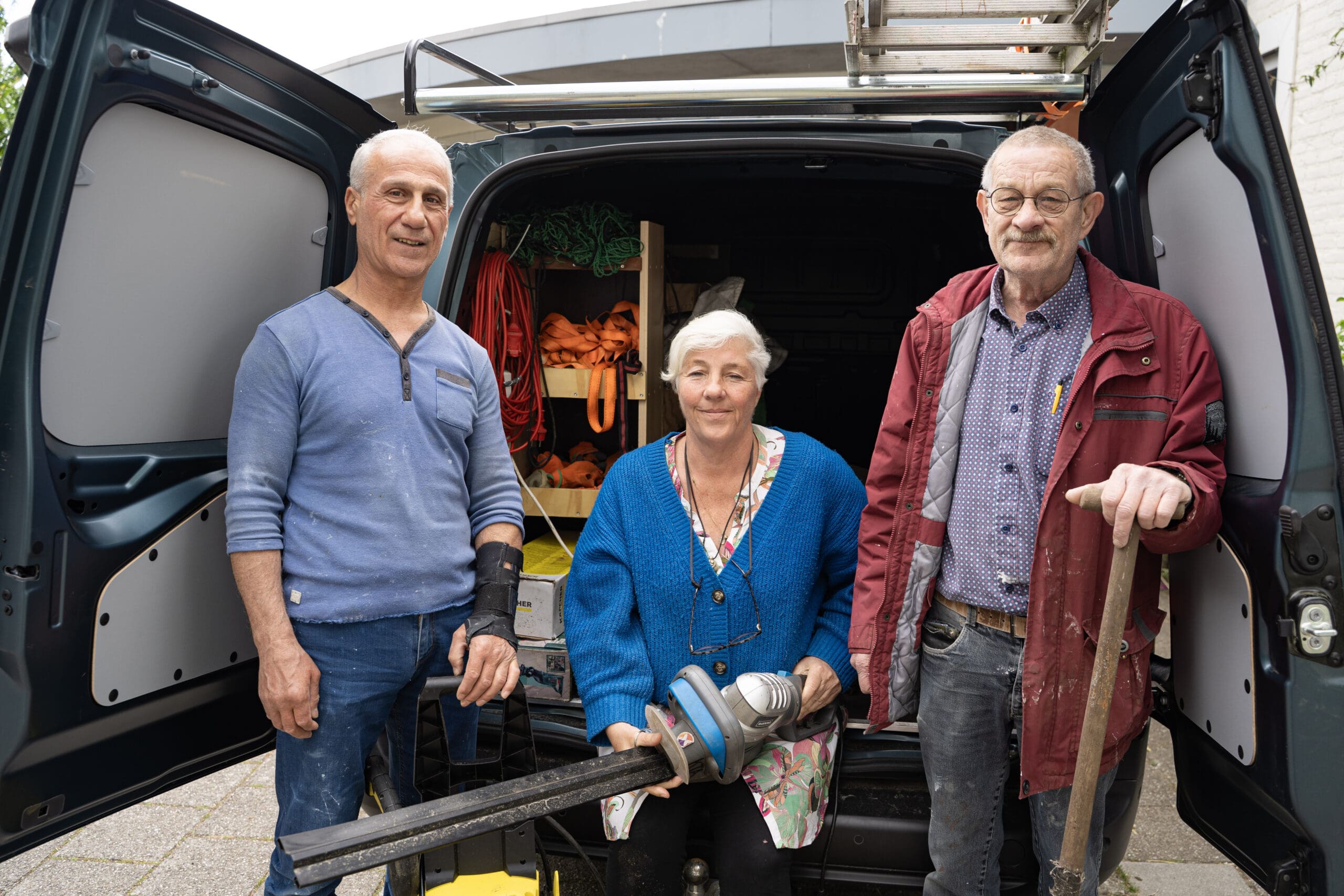 Coördinator Gemma van der Heijden en klussers Ab (68) en Yusef (64) voor de klusbus